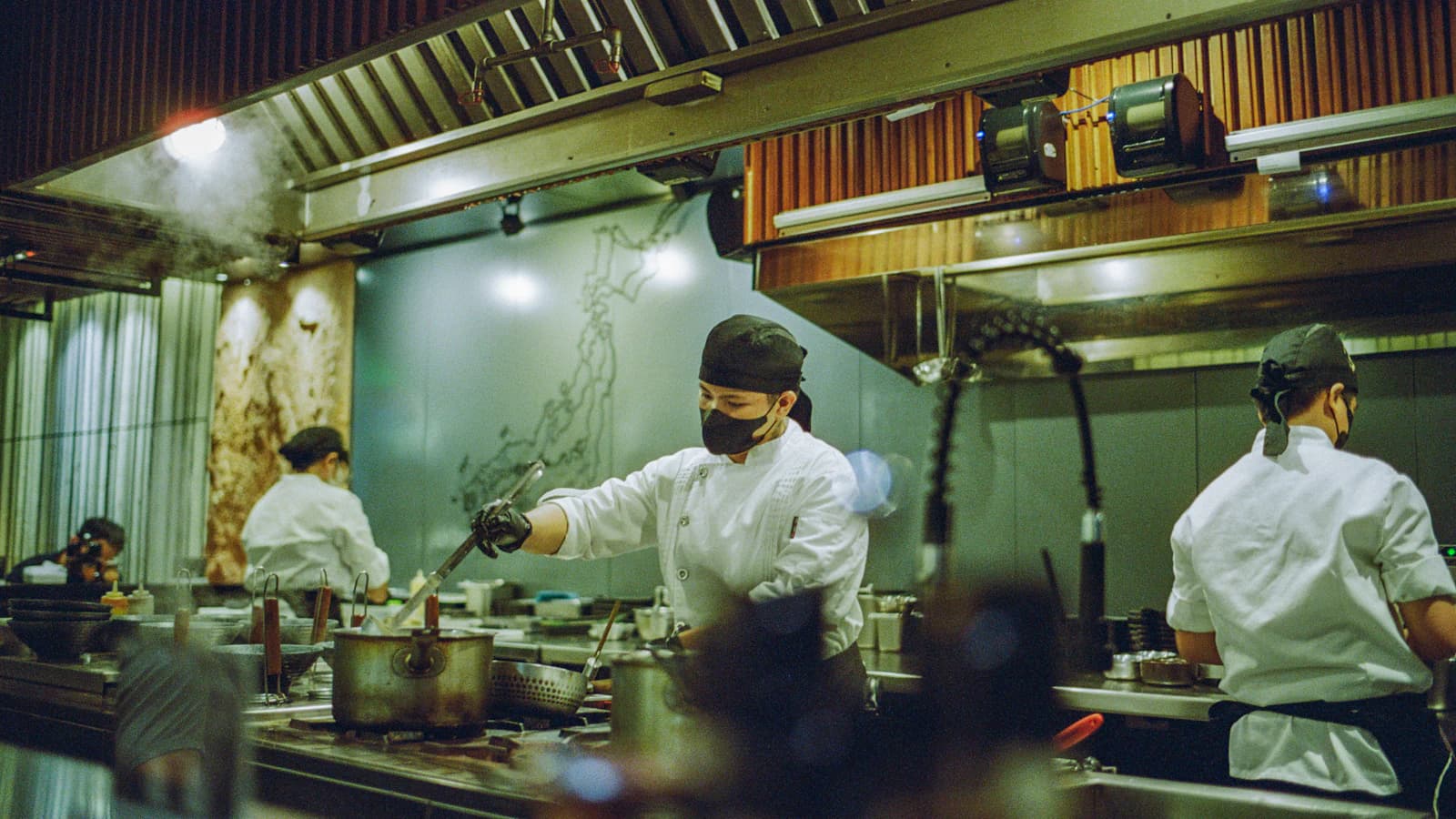 Équipe de cuisiniers qui travaillent ensemble en cuisine professionnelle, ambiance collaborative
