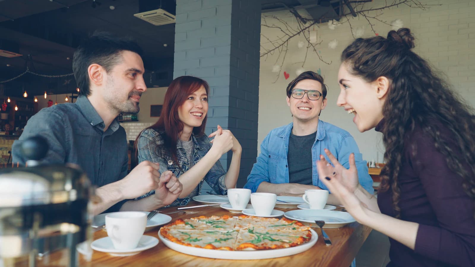 Amis qui partagent une pizza au restaurant, ambiance conviviale, habitués