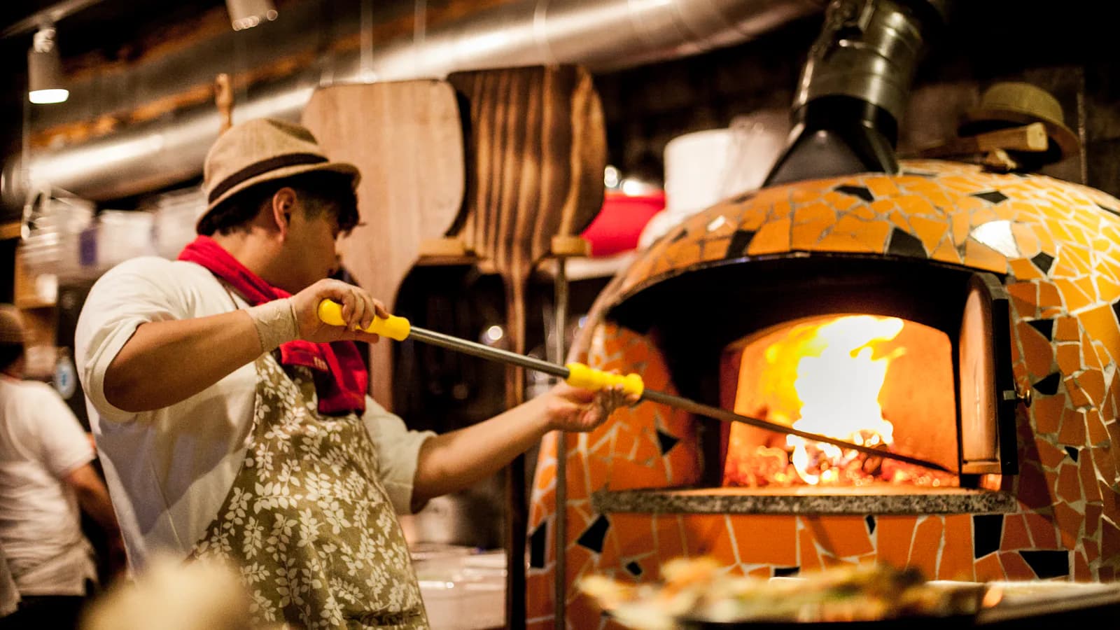 Pizzaiolo tenant une pelle à pizza en métal - le geste métier