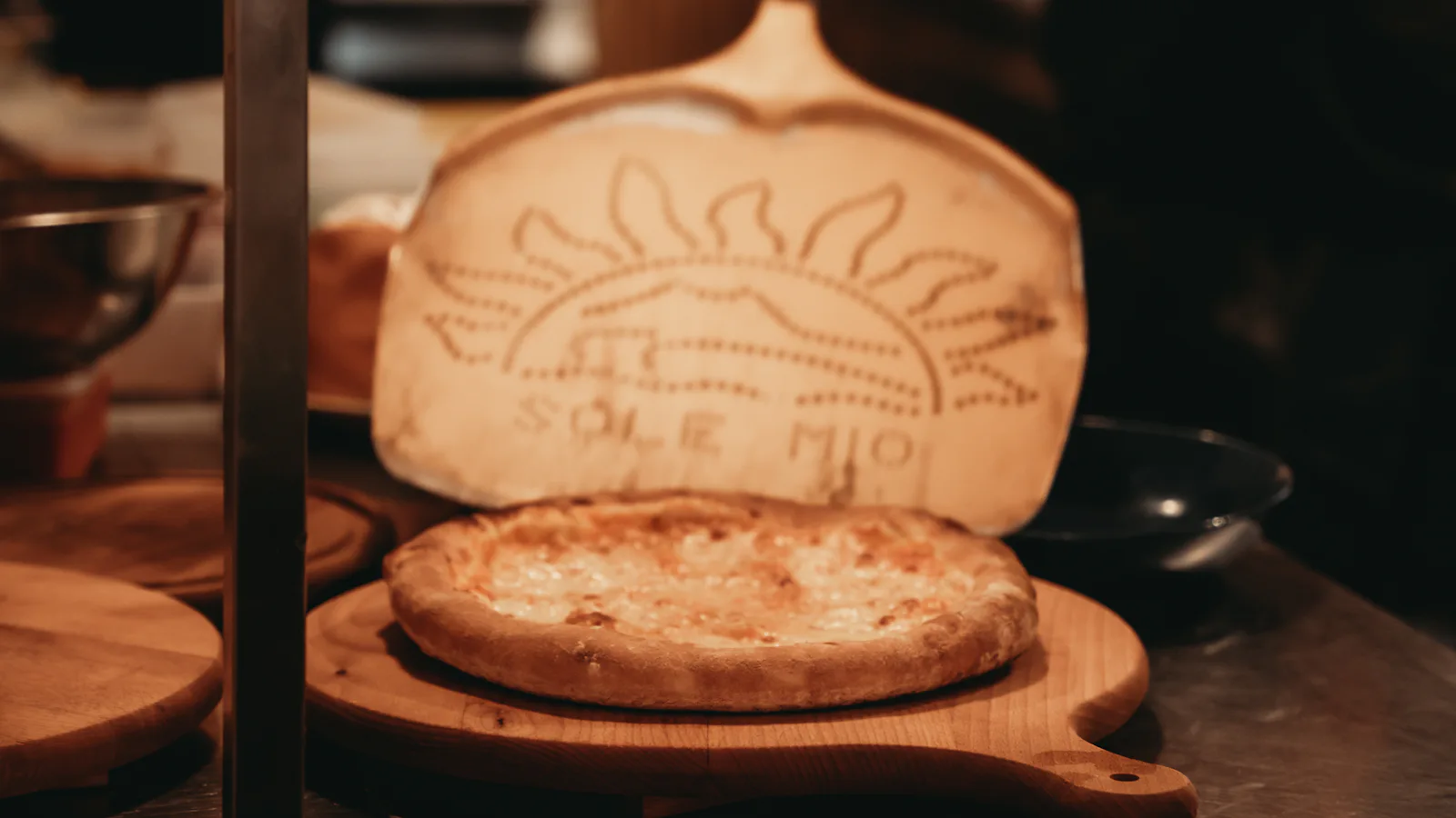 Pâte à pizza sur une pelle en bois avec motif soleil