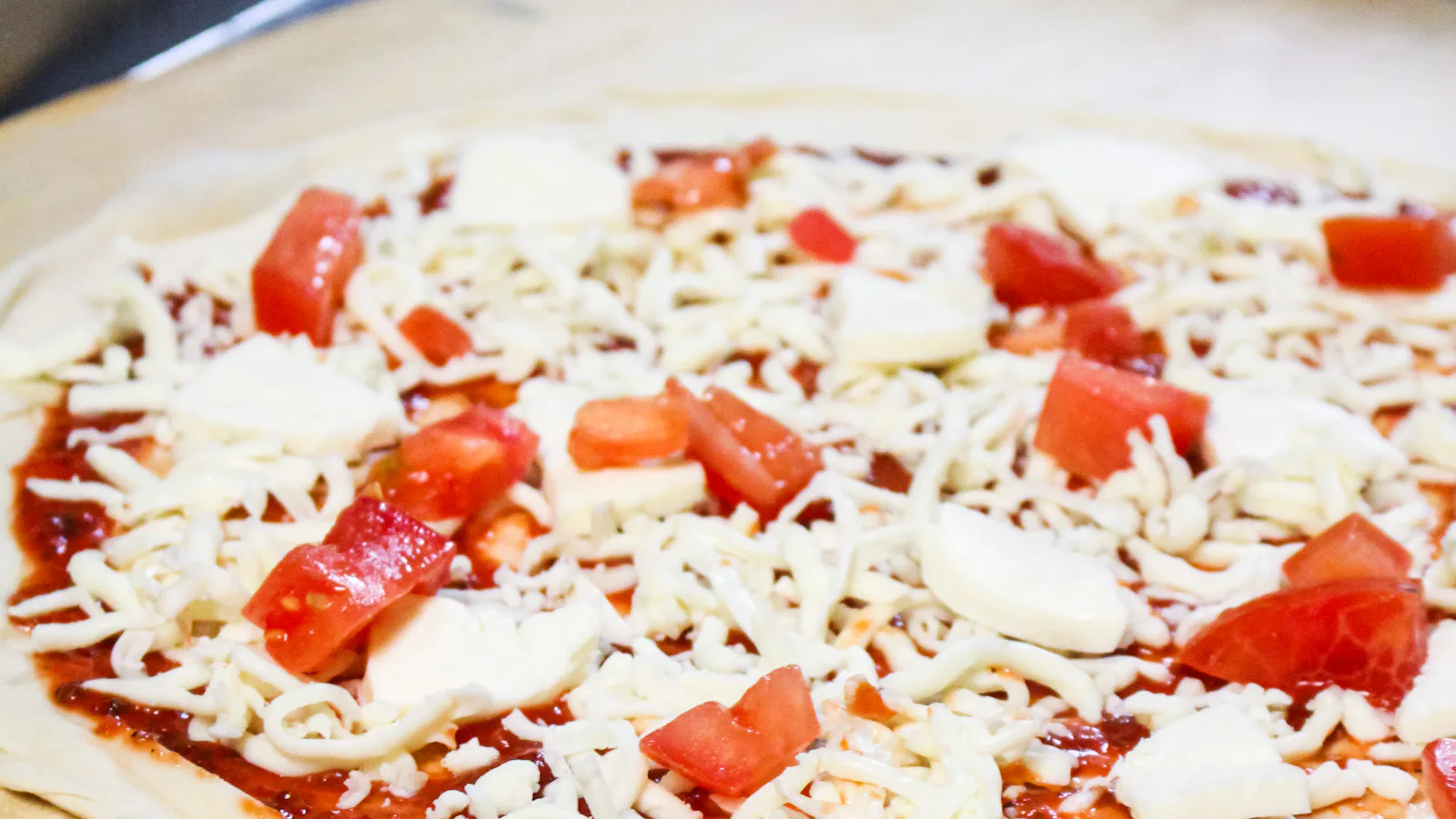 Pizza crue avec tomates et fromage mozzarella prête à enfourner