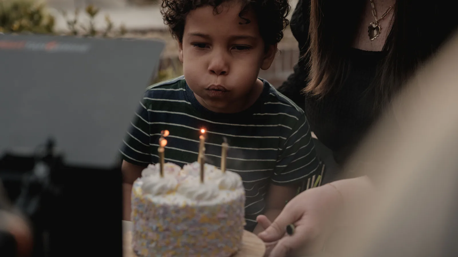 Jeune garçon qui souffle les bougies de son gâteau d'anniversaire